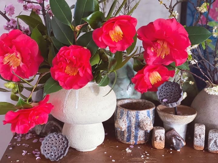 A table of glazed pieces with camellias