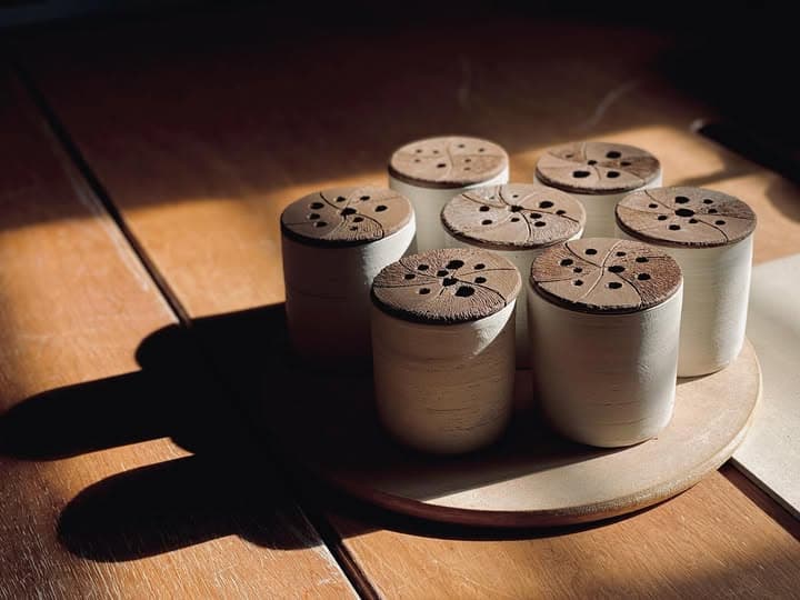 Lidded vessels with pierced tops in afternoon sun