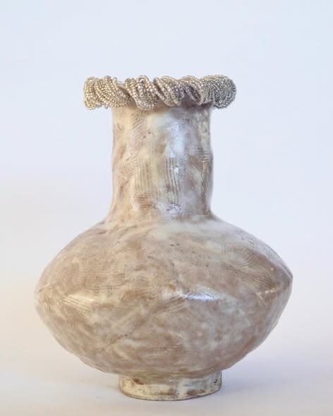 A cream stoneware vase with a beaded rim