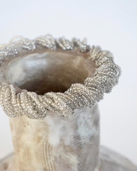 Detail of a glass bead rim on a stoneware vase